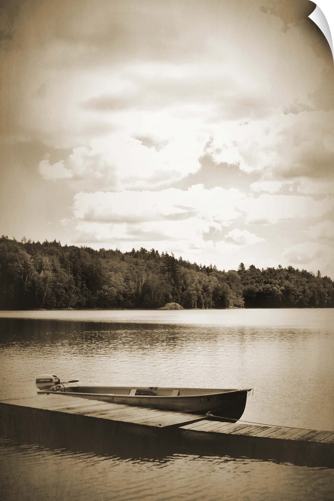 Sepia toned photograph of a boat dock floating gently in a lake, with a boat docked beside it.