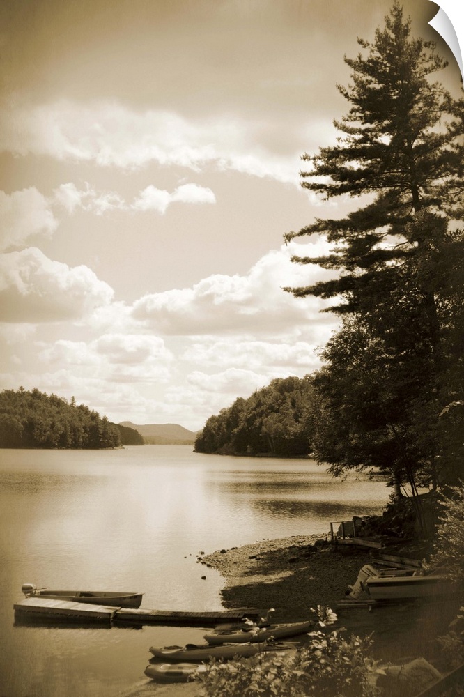 Sepia toned photograph of a boat dock floating gently in a lake, with a boat docked beside it.