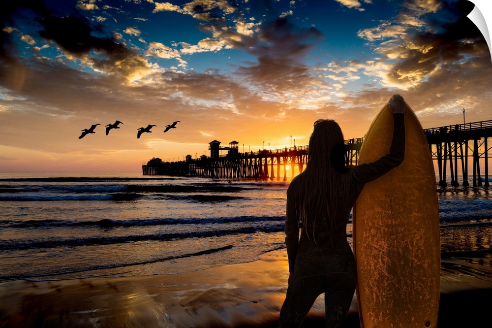 A female surfer watches the last waves near the Oceanside Pier, Oceanside, California, USA