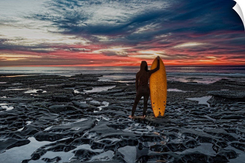 Female surfer and board near sunset cliffs, San Diego, California, USA