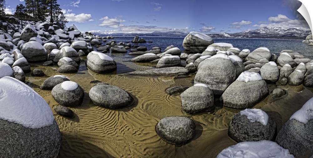 This is a panoramic capture of Snow-covered boulders in Lake Tahoe's Sand Harbor, California, USA.