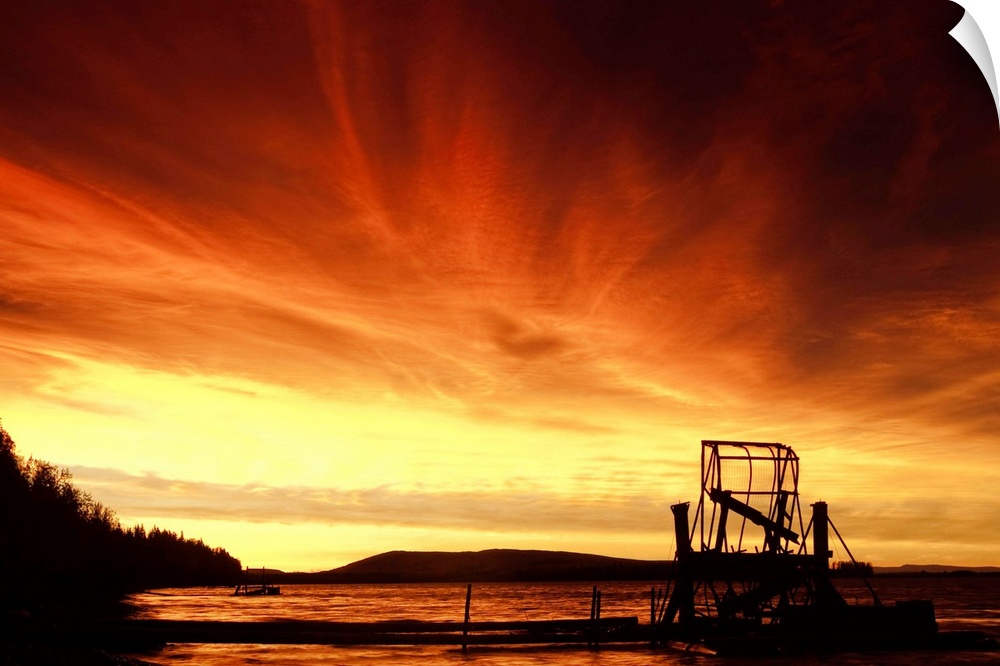 A fish wheel spins during an early morning sunrise on the Tanana River near the village of Tanana.  Interior, Alaska summer.
