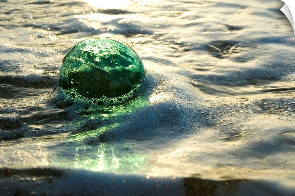 A Glass Fishing Ball Floats In Shallow Water