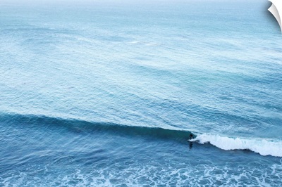 A lone surfer rides a Pacific wave.