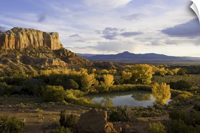 A Pond Is Seen Next To Kitchen Mesa With Pedernal Peak In The Distance