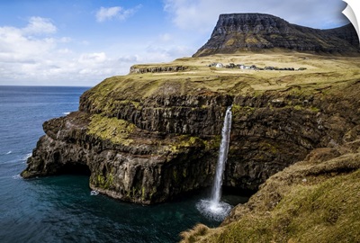 A Waterfall Cascades Down A Dramatic Rockface On The Faroe Islands