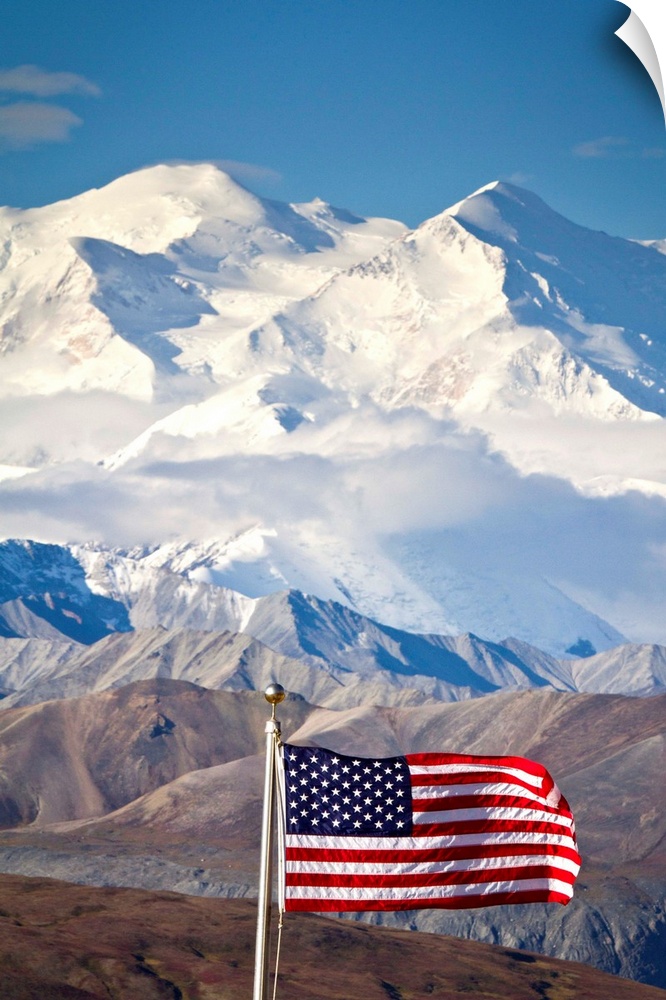 An American flag flys in the wind at Eielson Visitor Center in August at Denali National Park.  Mt. McKinley is in back of...