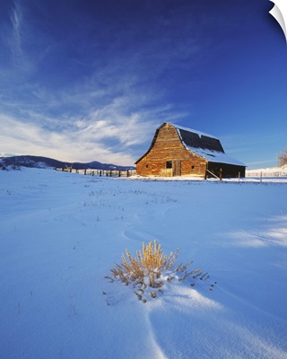 An old rustic weather worn western barn in snow