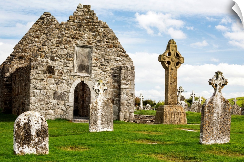 Ancient stone roofless church with celtic crosses in a grassy field, County Offaly, Ireland.