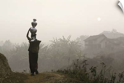 Bru Tribeswoman Carrying Water Pots On Her Head At Sunrise; India