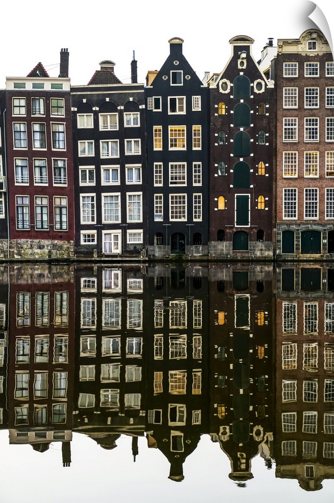 Building facades with a mirror image reflecting in a canal; Amsterdam, Netherlands