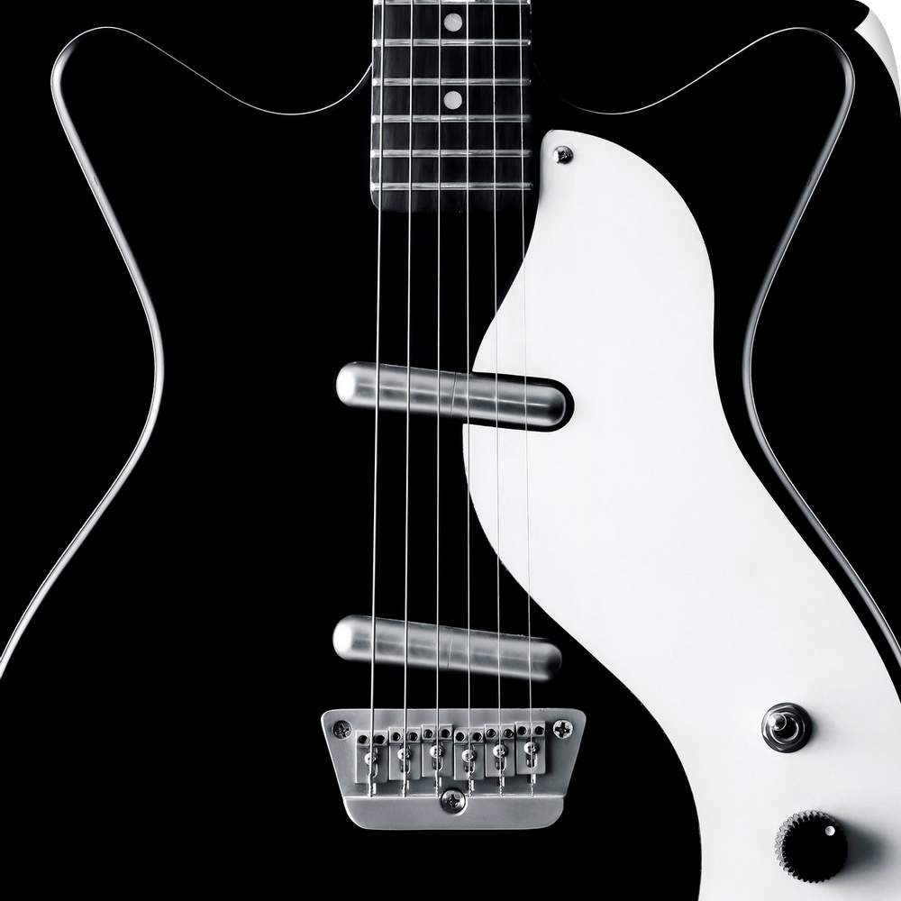 Close-up of a black and white electric guitar.