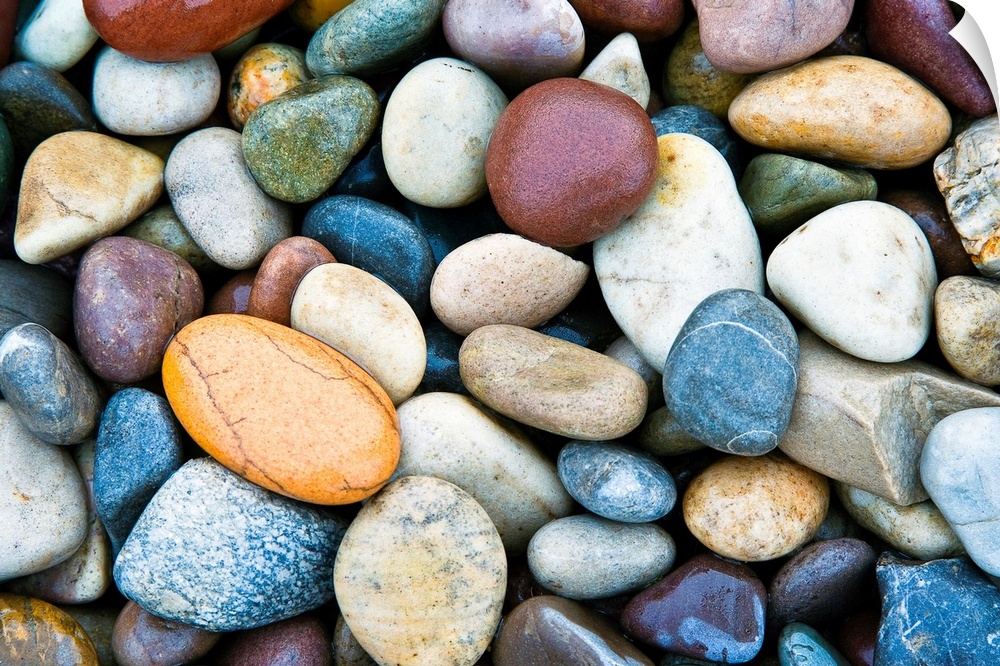 A horizontal photograph of smooth river stones piled on a beach. This calming photograph would make a wonderful decorative...
