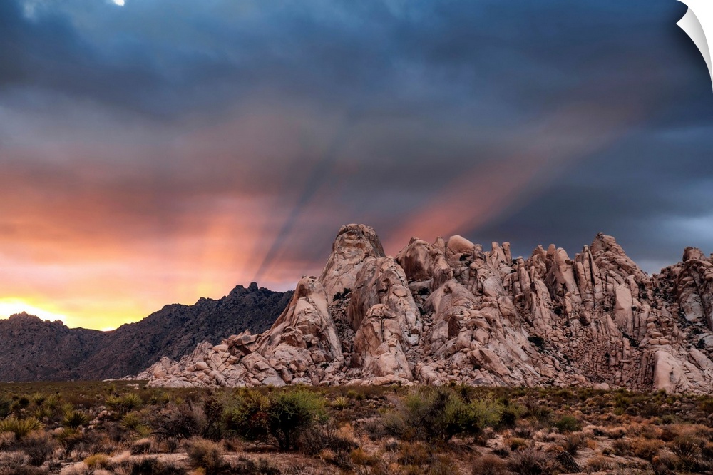 Crepuscular rays at sunset behind rock formations in the Mojave Desert, Kelso, California, United States of America
