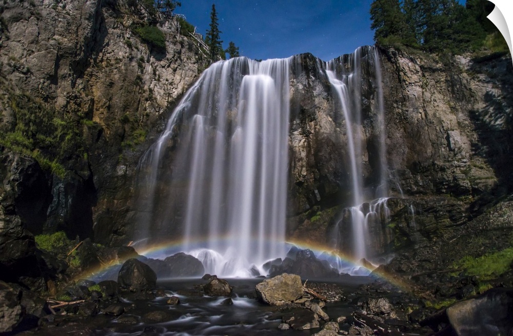 Stunning, Dunanda Falls at night with a lunar rainbow along the Boundary Creek Trail in Yellowstone National Park Wyoming,...