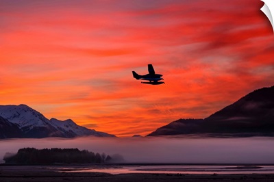 Floatplane takes off from Juneau as the fog begins to clear at sunrise, Southeast Alaska