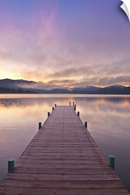 Footprints leading down a frost covered dock at sunrise on Lake Whatcom during Winter