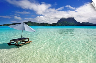 French Polynesia, Tahiti, Bora Bora, Picnic Table And Umbrella In Clear Lagoon Water
