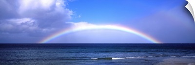 Full Rainbow Over Ocean, Large Clouds Against Blue Sky