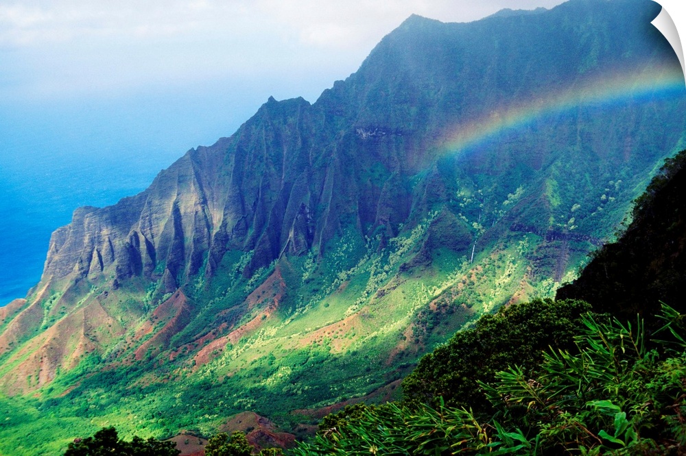 Large canvas photo art of a rainbow in the middle of lush Hawaiian mountains.