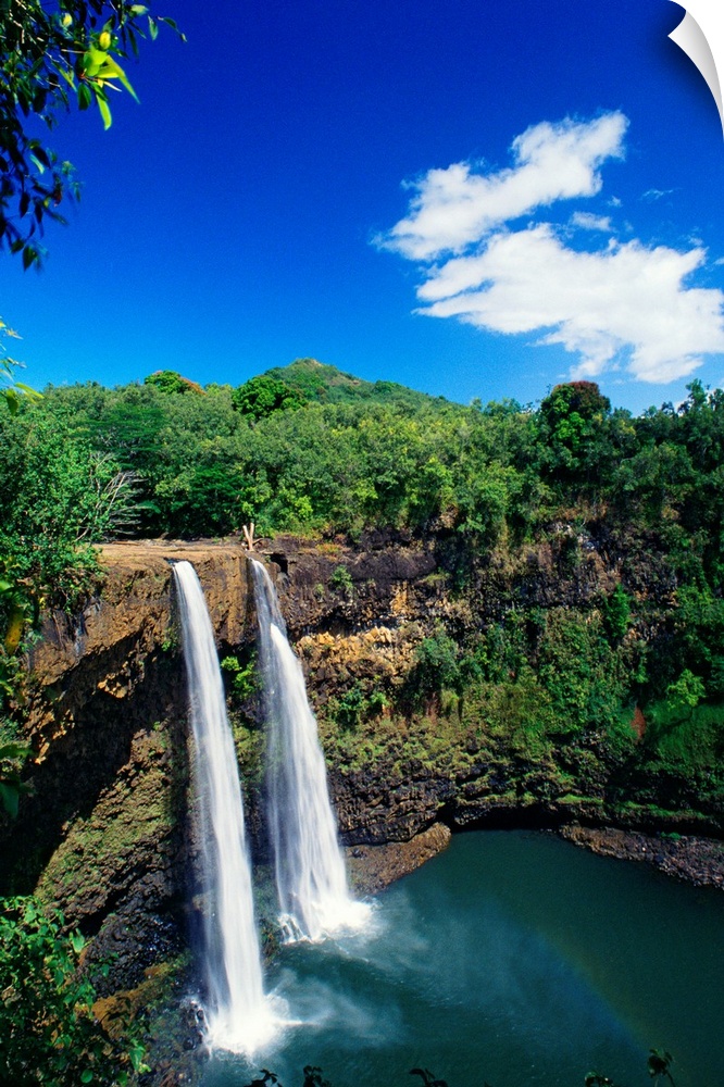 Tall canvas of two waterfalls right next to each other sending water down to the lake below in Hawaii.