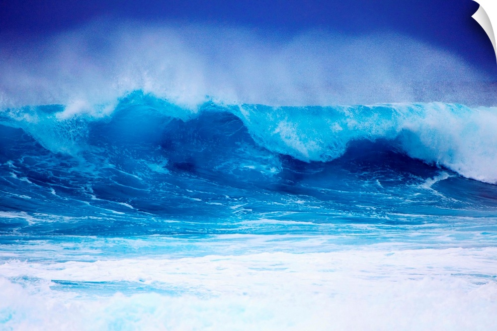 Giant horizontal photograph of a vibrant blue wave spraying upward as it begins to crash onto itself, against a deep blue ...