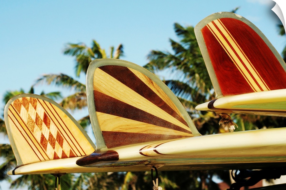 Up-close photograph of three patterned surfboard fins.