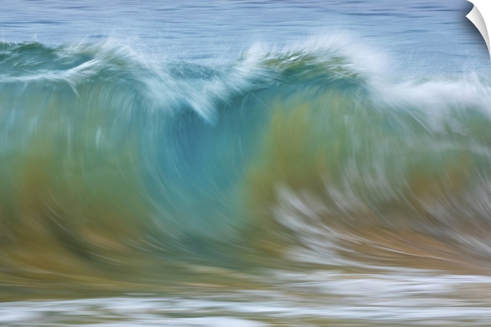 Motion blur of blue rolling waves carrying golden sand at the shore; Kihei, Maui, Hawaii, United States of America.