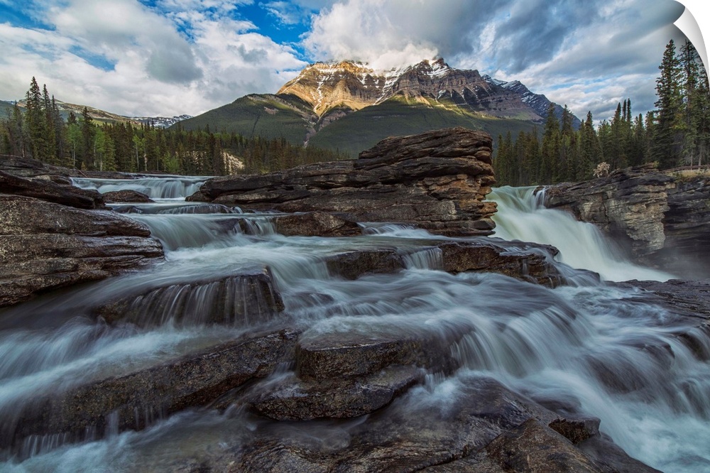 Late afternoon sun lights up Mount Fryatt as the Athabasca River flows over Athabasca Falls in Jasper National Park, Alber...
