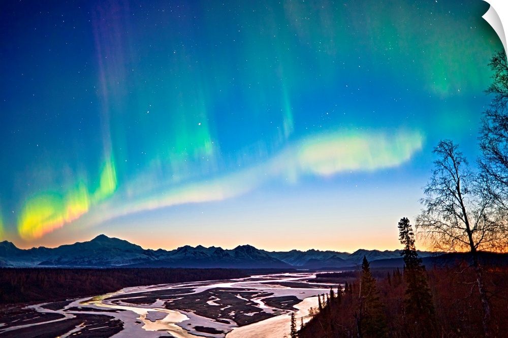 Northern Lights in the sky above Mount McKinley and the Alaska range at twilight with the glow from the  setting sun low o...
