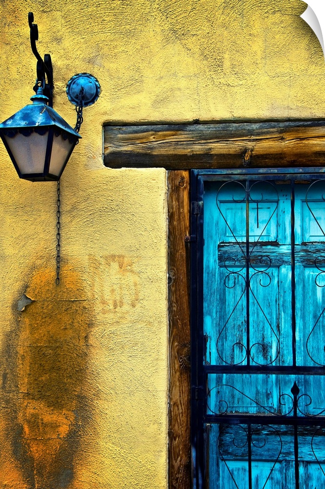 Vertical panoramic photograph of bright colorful door on stone wall.