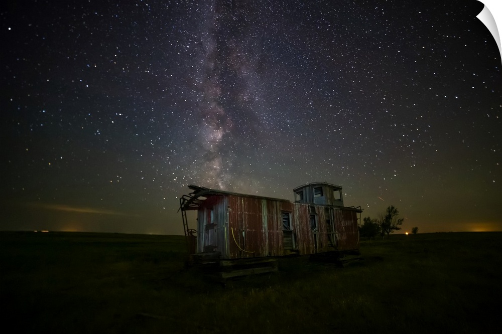 Old caboose at nighttime under a bright, starry sky; Coderre, Saskatchewan, Canada