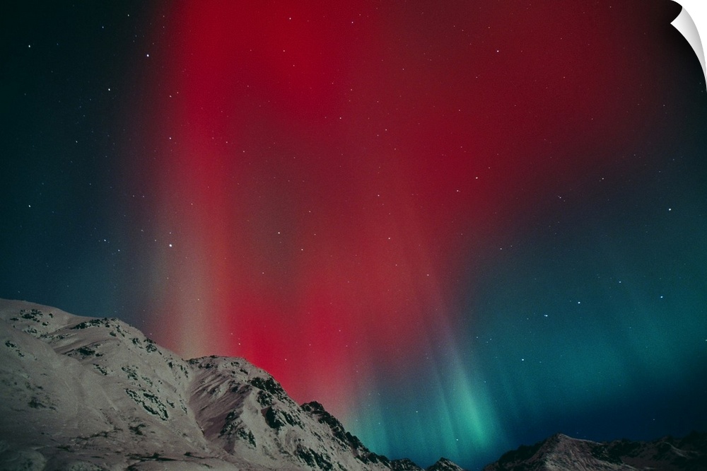 Photo on canvas of an aurora in the night sky above snow covered rugged mountains.