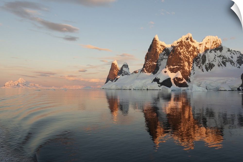 Reflections of cliffs and mountains in the Lemaire Channel at sunset, Antarctica