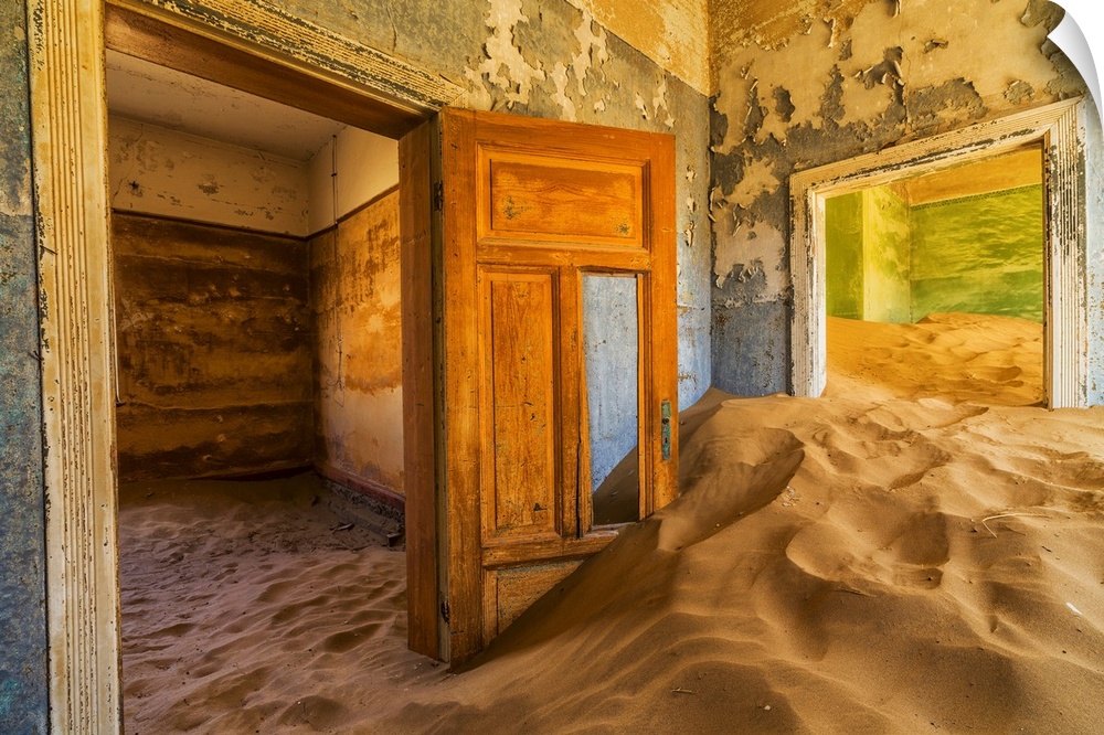 Sand in the rooms of a colourful and abandoned house. Kolmanskop, Namibia.