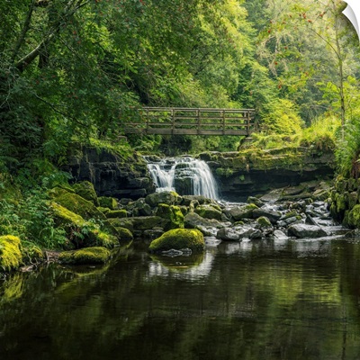 Small Waterfall Flowing Beneath A Rustic Wooden Bridge, Alston, Cumbria, England