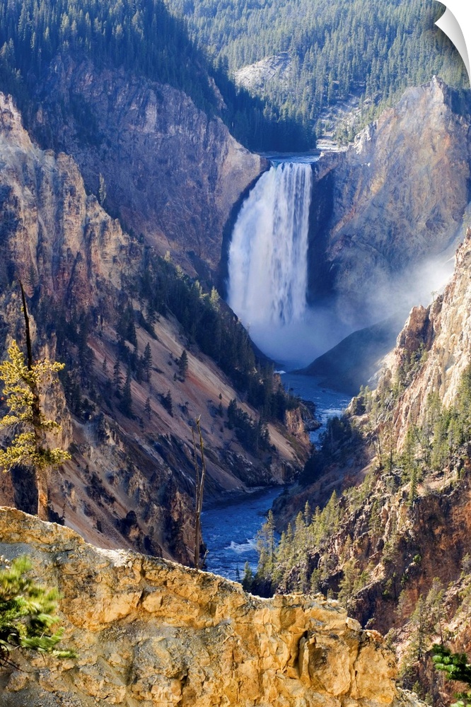 Sunlit sulphuric rock of the cliffs surrounding the Lower Falls of the Yellowstone River in the Grand Canyon of the Yellow...