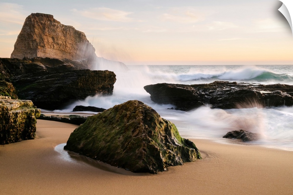 Sunset along the central California coast with waves crashing onto the large rocks on the beach Santa Cruz, California, Un...