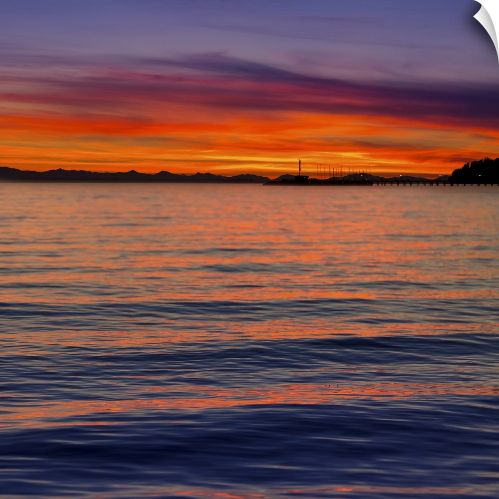 Dramatic and vibrant sunset with a silhouetted coastline; Whiterock, British Columbia, Canada