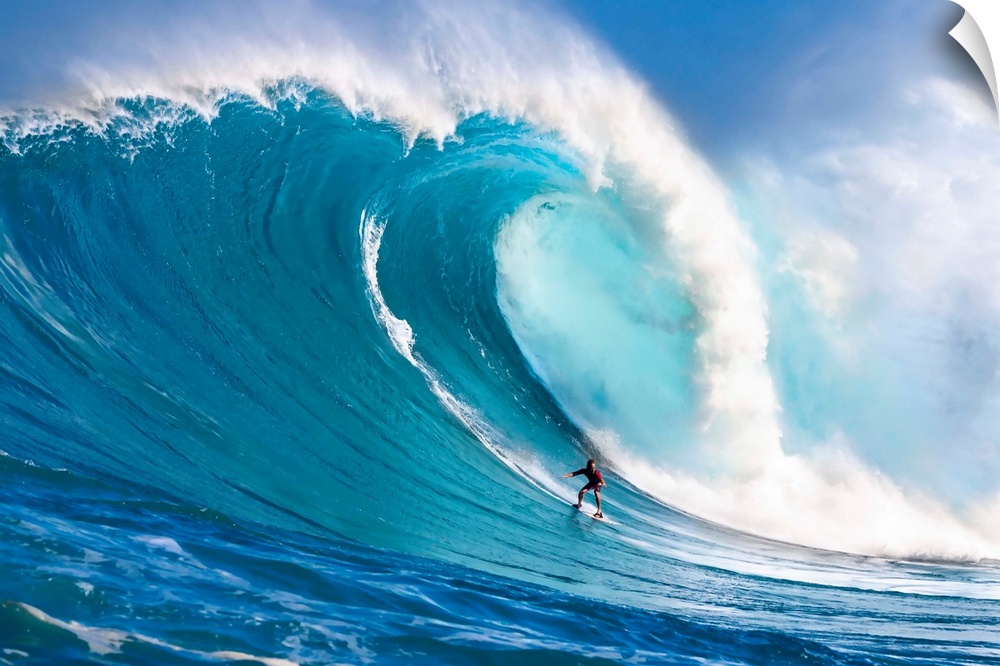 A tow-in surfer drops down the face of Hawaii's big surf at Peahi (Jaws) off North shore Maui; Maui, Hawaii, United States...