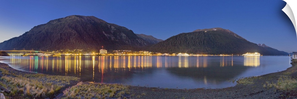 Downtown Juneau photographed across the water from Douglas Island, city lights reflected in the water, twilight, summer, J...