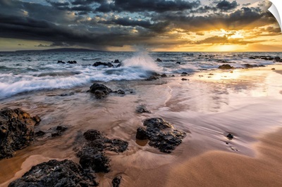 Water splashing on the beach with a golden sunset over the ocean, Hawaii