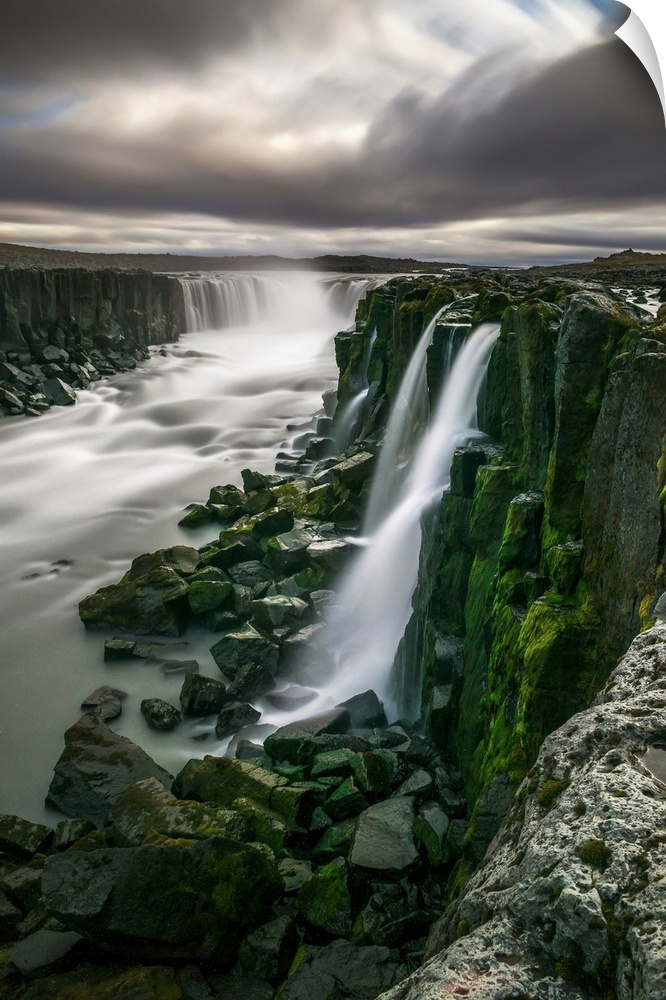 Waterfall flowing over moss covered cliffs; Selfoss, Iceland