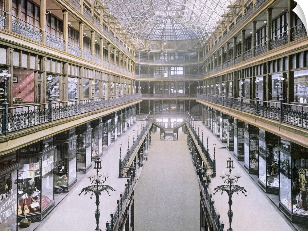 A vintage picture taken inside of the arcade showing various shops on three levels on both sides of the building.