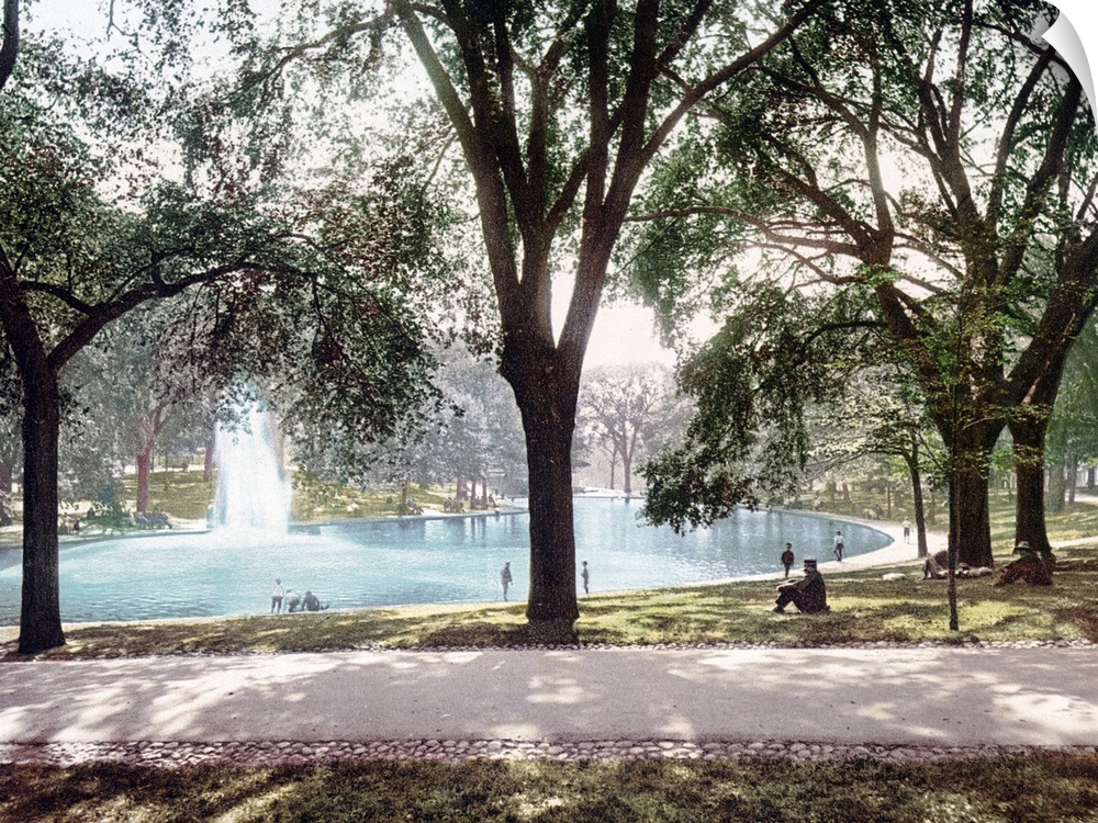 Vintage colored photograph of a pond in Boston Common Park with a spouting water feature in the middle of the pond and tre...
