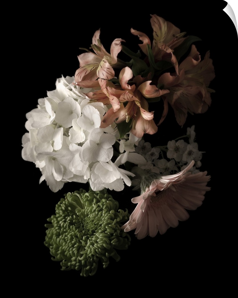 Moody photograph of a bouquet of pastel flowers on black in low light.
