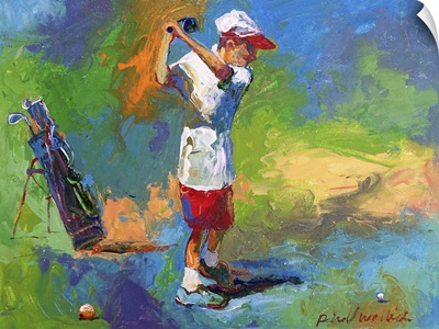 A young boy swinging at the golf ball