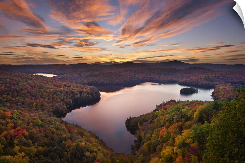 A photograph of a wilderness landscape at sunset with a lake in the foreground.