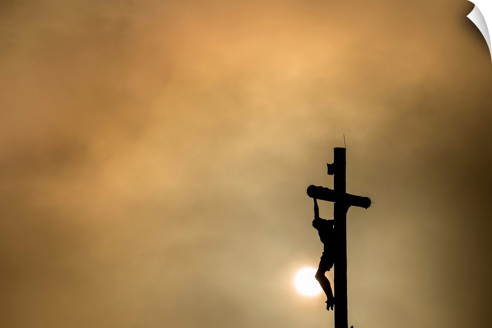 Silhouette of Christ on the cross at sunset.