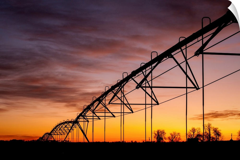 Beautiful sunset photograph with a silhouette of a farms irrigation system.